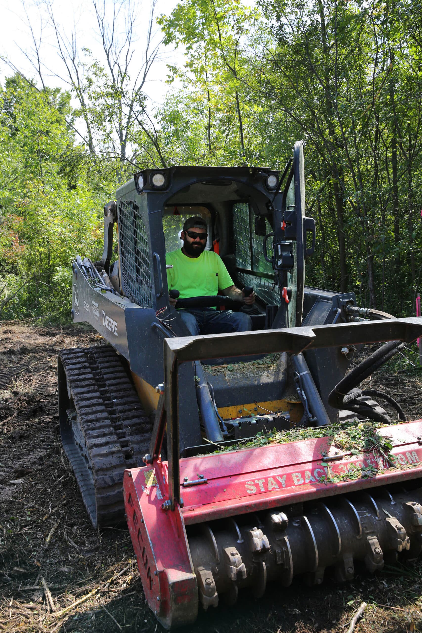 Wisconsin Land Management Work Ethic Cody, owner of Wisconsin Land Management, operating a John Deere compact track loader with a Fecon forestry mulching head.